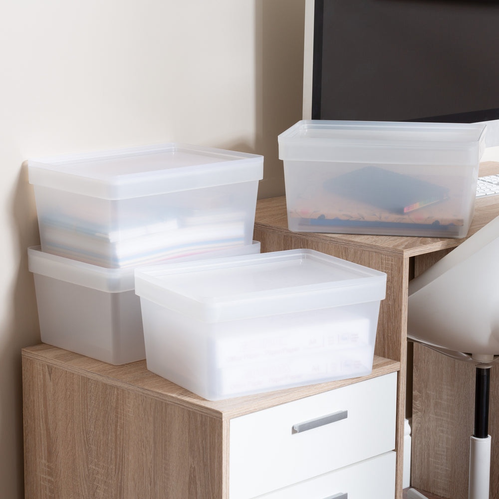 Stack of clear plastic storage boxes on a wooden shelf with a neutral background